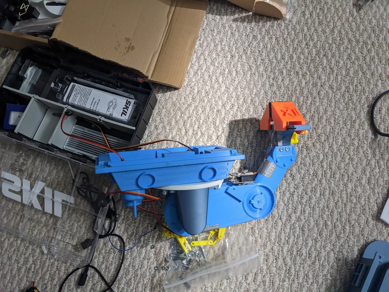 The printed arm, base and other parts laid out on the floor during assembly
