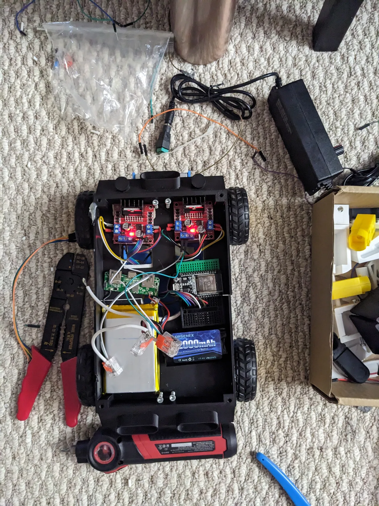 The rover base opened to show wiring, motor drivers and a battery