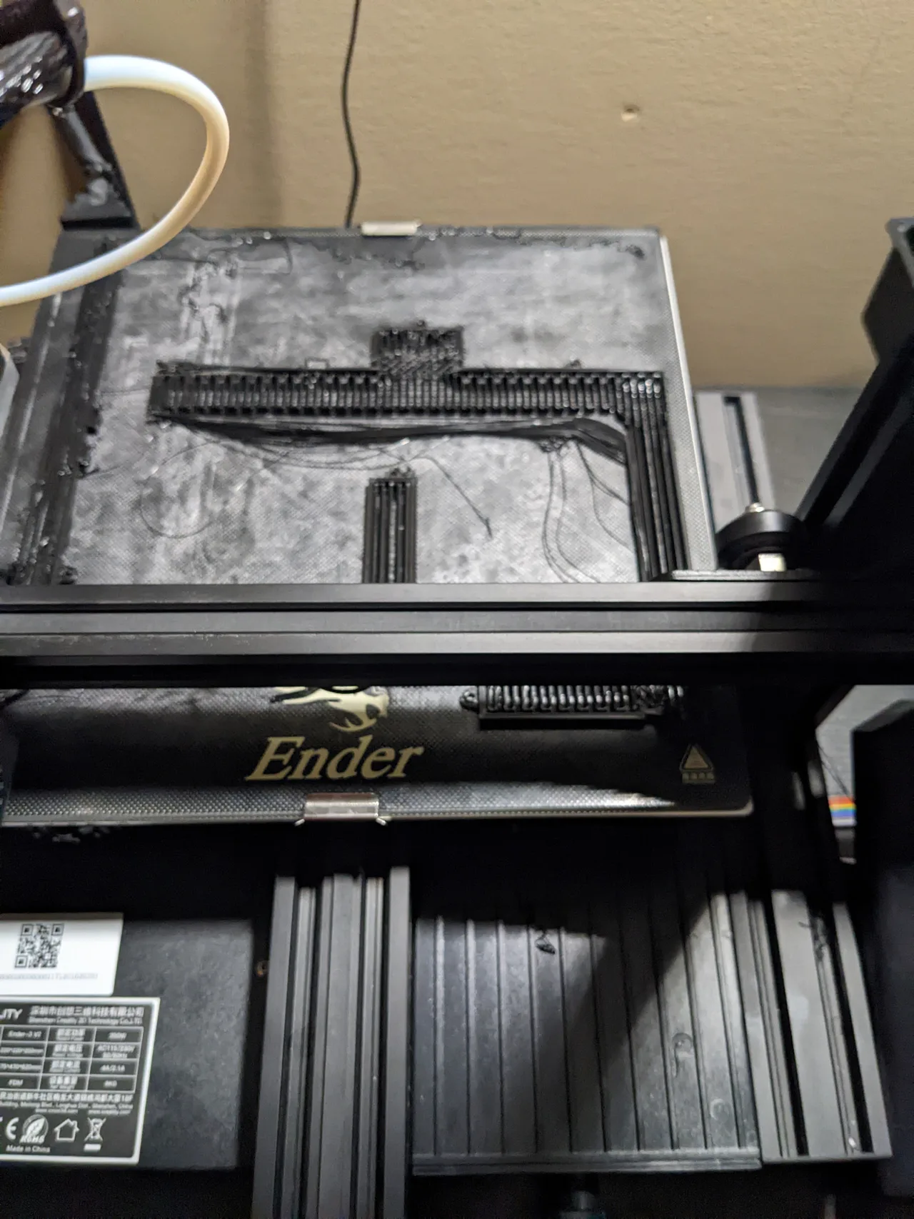 Long black traffic-light supports printing on an Ender build plate