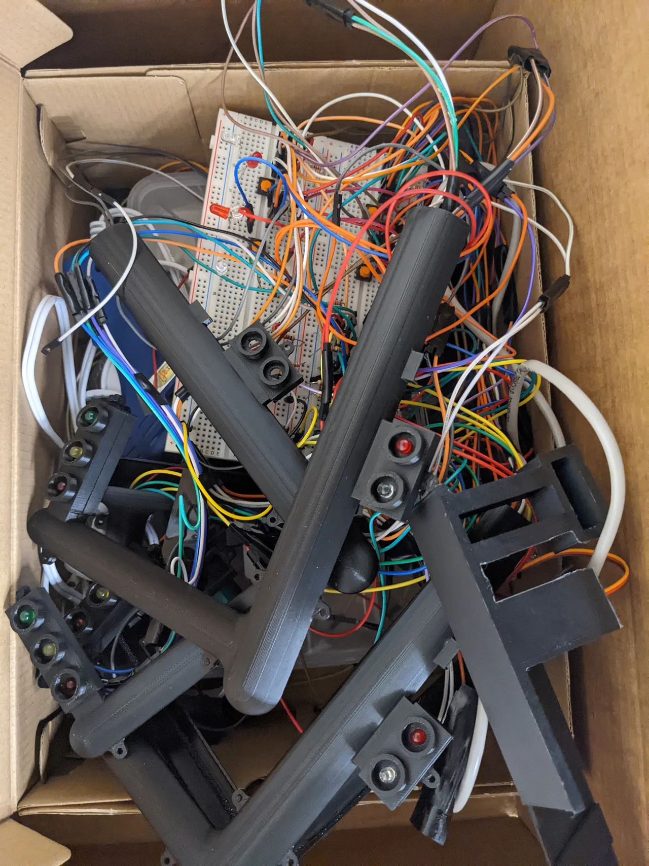 Assembled traffic-light heads with three circular lights each, surrounded by wiring in a box